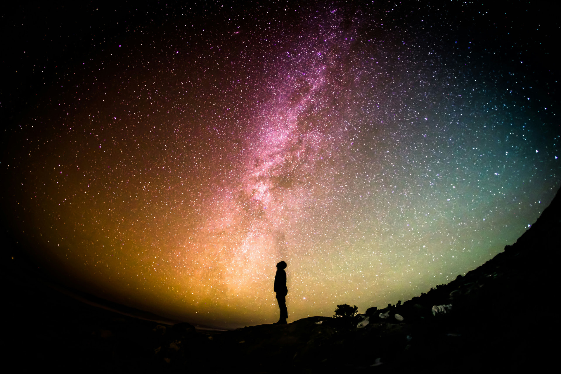 A lone figure looking up at a star-filled night sky